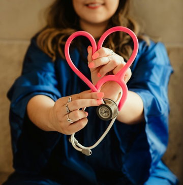 girl in blue jacket holding red and silver ring
